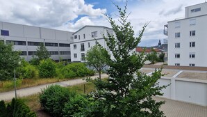 A residential area with modern buildings, a paved walkway, and well-maintained greenery.
