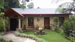 A house with a porch, a garden, and a bicycle. - Eco Hotel Villa Canaan (Cobán)