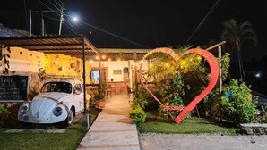 A cafe with a vintage car parked outside, a heart-shaped decoration, and a signboard. - Eco Hotel Villa Canaan (Cobán)