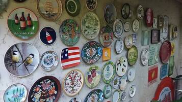 A wall covered with various decorative plates and tiles, including some with text and images.