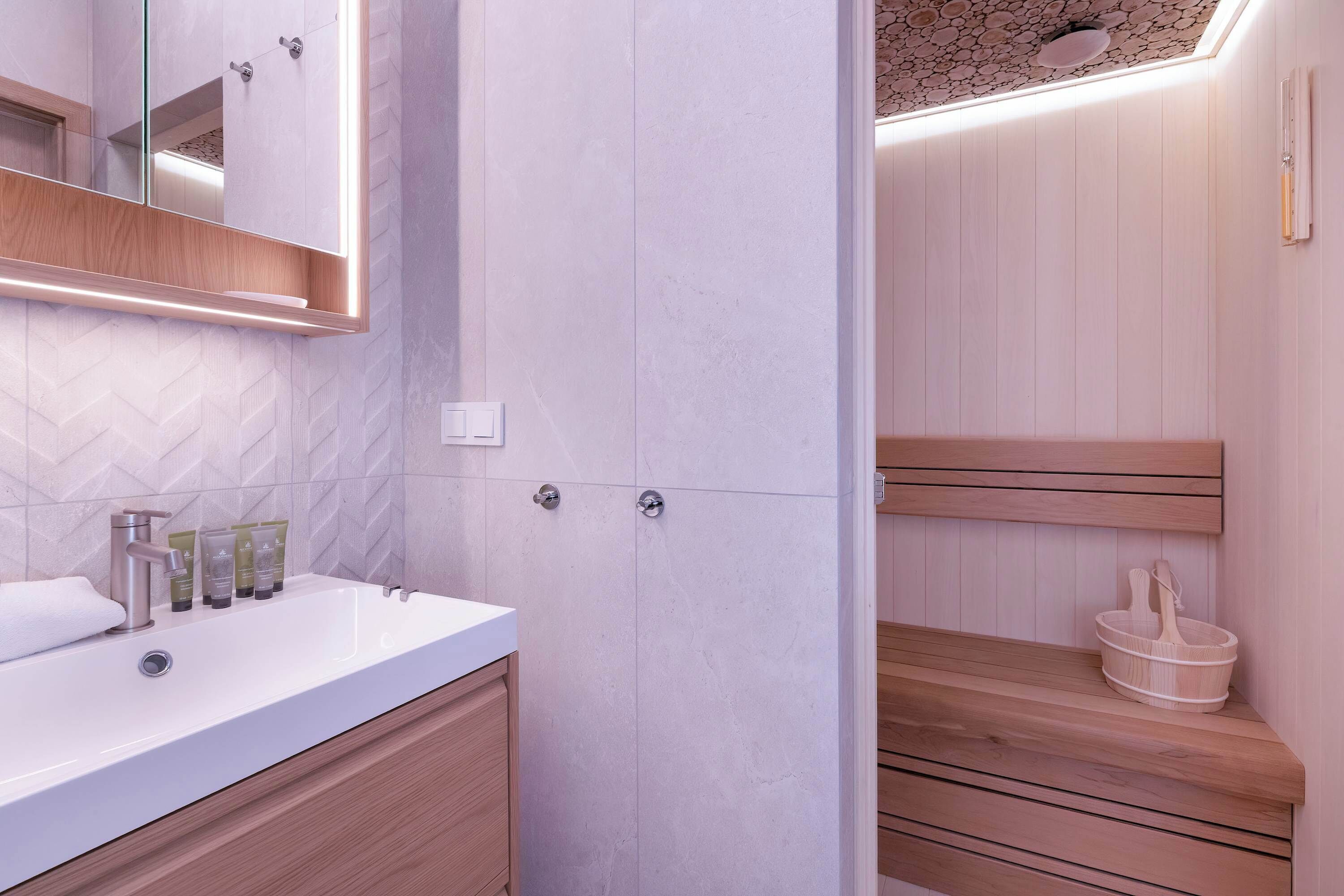 Une salle de bain moderne avec un lavabo blanc, un miroir et un meuble-lavabo en bois.