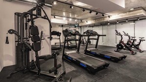 Ein Fitnessraum mit Laufbändern, Krafttrainingsgeräten und einem Ergometer.