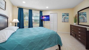 A bedroom with a bed, a TV, a dresser, and a window with curtains. - Vacational Apartment at Orlando 3608 (Orlando)