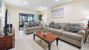 A living room with two sofas, a coffee table, a TV, and a large window. - Vacational Apartment at Orlando 3608 (Orlando)