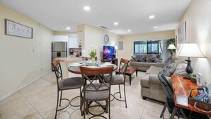 A modern living room with a dining area, a sofa, and a TV. - Vacational Apartment at Orlando 3608 (Orlando)