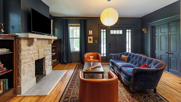 Una sala de estar con chimenea, un sofá, una mesa de centro y un televisor.