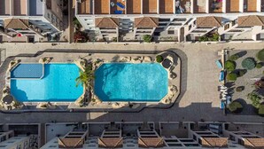 An aerial view of a hotel with two large swimming pools, a rooftop bar, and a landscaped garden area. - Holiday Home Paphos - Near Amenities - Poolside (Paphos)