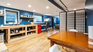 Una cocina moderna con armarios de madera, un refrigerador rojo y un gran comedor de madera.