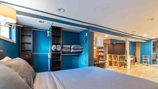 Un dormitorio moderno con una cama grande, armario empotrado y zona de televisión.