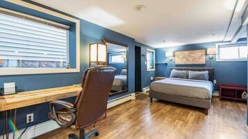A bedroom with a bed, a desk, and a chair.