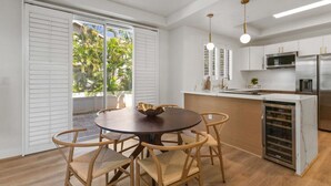 A modern kitchen with white cabinets, stainless steel appliances, and a central island with seating.