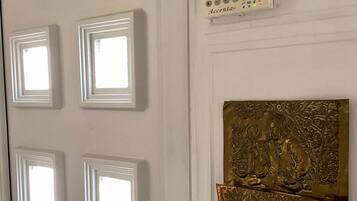 A white door with a keypad lock, a silver handle, and a brass doorknob.