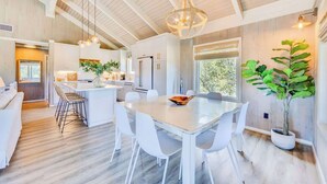 A modern kitchen with white cabinetry, a central island, and pendant lighting.