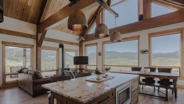 Una cocina amplia con ventanas grandes, vigas de madera y una isla central.
