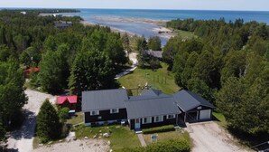 Ein Wohngebiet mit einem Haus, einem Gebäude mit rotem Dach und einem Strand im Hintergrund.