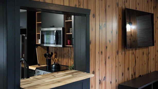 A kitchen with a wooden countertop, a microwave, and a stove.