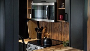 A kitchen with a microwave, stove, and wooden cabinets.