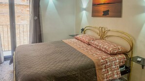 A bedroom with a bed, a painting, and a window with curtains. - Romano Apartment - Trapani (Trapani)