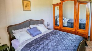 A bedroom with a wooden bed, a wardrobe, and a framed picture on the wall. - Monte Oliveto House - Apartment 3 (Bettona)