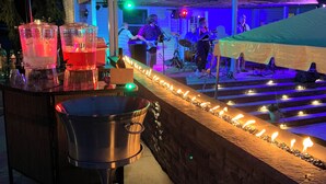 An outdoor bar area with a stone wall, bar stools, and a red umbrella. - Spacious 5-bedroom house in nice Winfield with WiFi, Pool and Hot tub (Winfield)