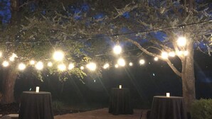 An outdoor area with brick flooring, tables covered with black cloths, and string lights overhead. - Spacious 5-bedroom house in nice Winfield with WiFi, Pool and Hot tub (Winfield)