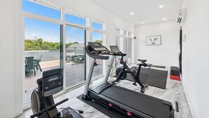 A modern home gym with a treadmill, stationary bike, and exercise equipment.