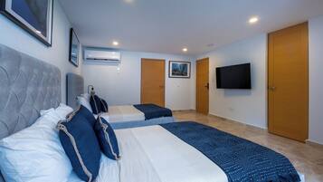 A hotel room with two beds, a flat-screen TV, and a large window.
