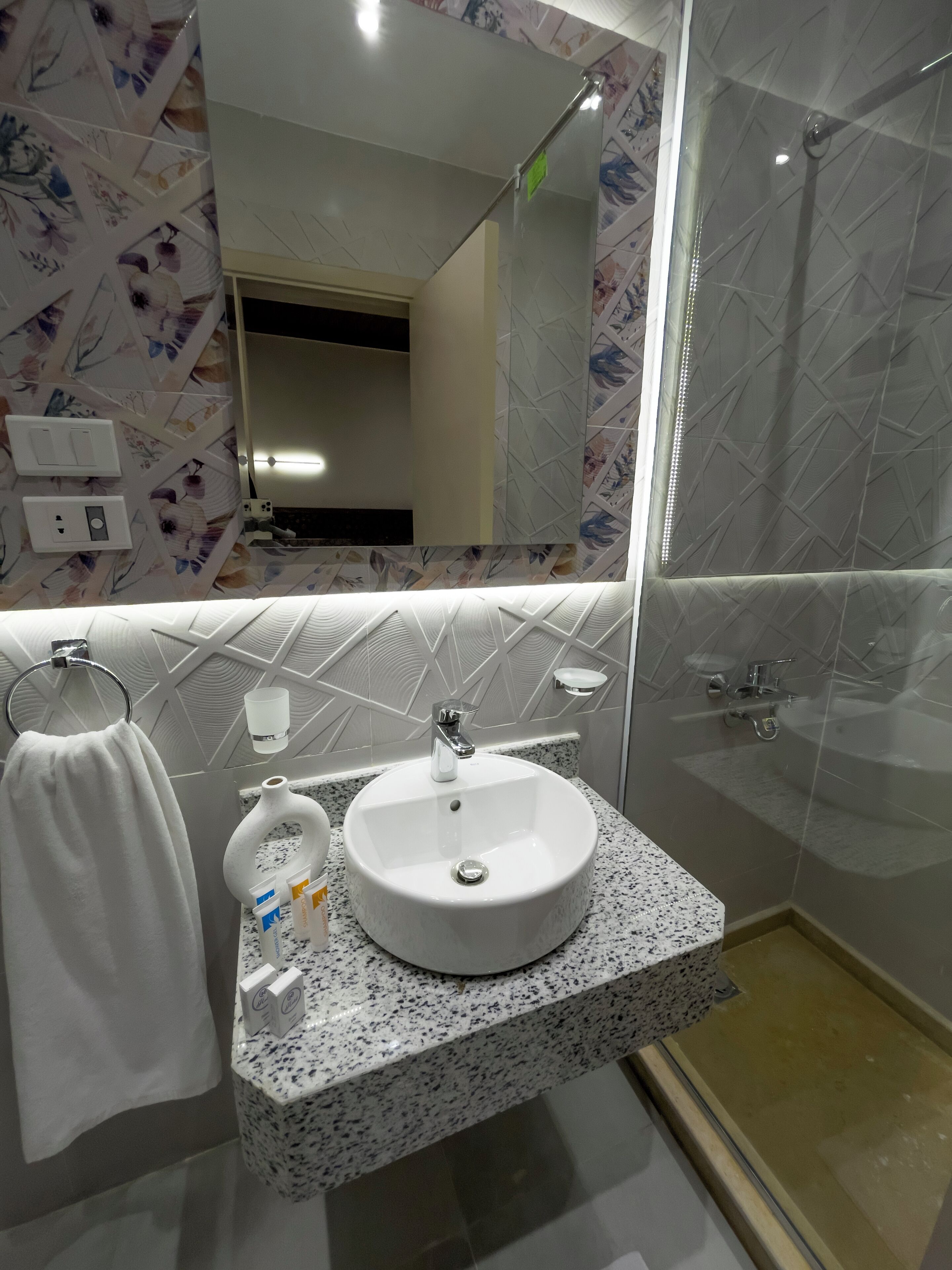 A bathroom with a white sink, a towel rack, and a mirror.