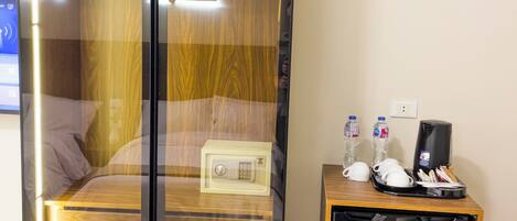 A room with a bed, a minibar, and a small refrigerator.
