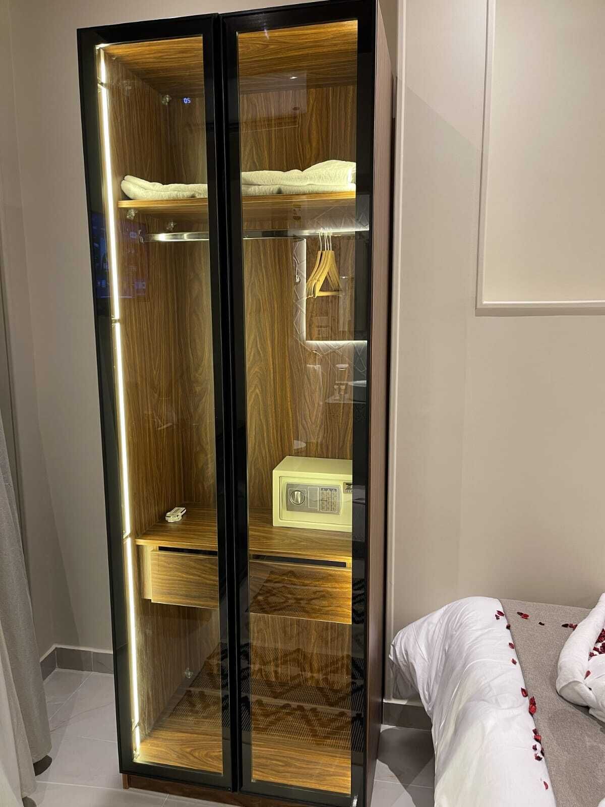 Un armario alto y moderno con frente espejada y interior de madera.
