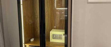 Un armario alto y moderno con frente espejada y interior de madera.