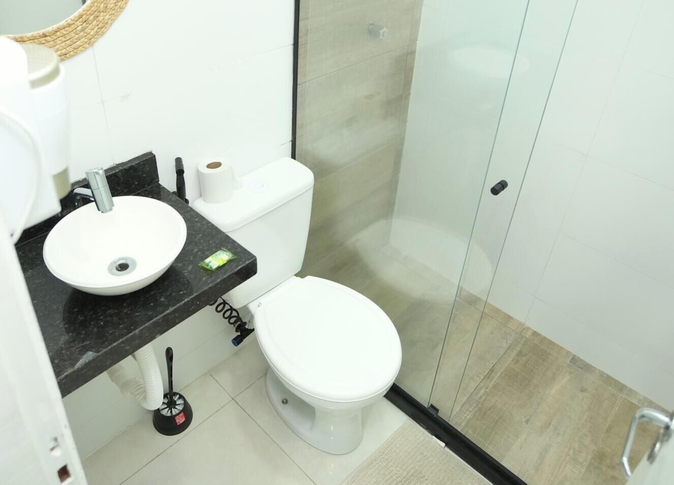 Een badkamer met een wit toilet, een wastafel en een douchehoek.