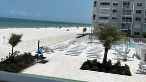 A beachfront hotel with a pool area, beach access, and a view of the ocean. - 2-bedroom 2 bathroom condo right on the beach in beautiful Naples, FL (Naples)