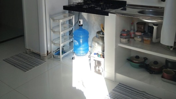 Una cocina compacta equipada con refrigerador, estufa a gas y microondas.
