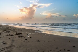 Peaceful beachfront sunset with wide sandy shores and rolling waves