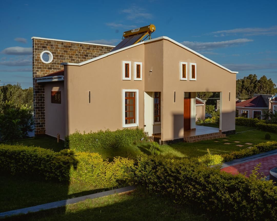 A modern two-story house with a flat roof, a chimney, and a small circular window on the side.