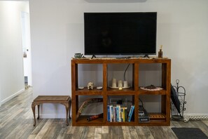A wooden entertainment center with a flat-screen TV, books, and decorative items.