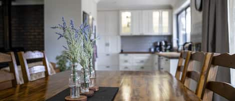 A dining table with chairs, a black placemat, and vases with lavender.