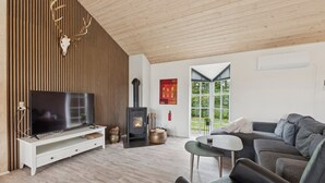 Un salon moderne doté d’un téléviseur, d’une cheminée et de sièges confortables.