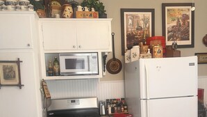 Une cuisine compacte équipée d’une cuisinière, d’un four, d’un four à micro-ondes et d’un réfrigérateur.