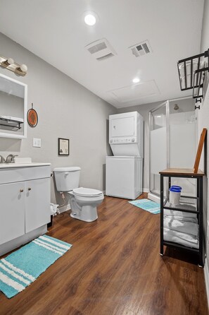 A compact bathroom with a toilet, sink, and a shower area.