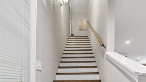 Un escalier avec des murs blancs et des marches en bois.