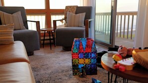 Ein Wohnzimmer mit einer Couch, Sesseln, einem Couchtisch und einer farbenfrohen geometrischen Skulptur.