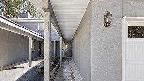A covered outdoor corridor with a white door and a wall-mounted light fixture. - The most affordable winter adventure stay in McCall!  (McCall)