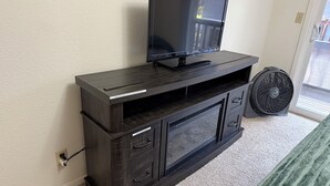 A dark wood entertainment center with a flat-screen TV and a fan. - The most affordable winter adventure stay in McCall!  (McCall)