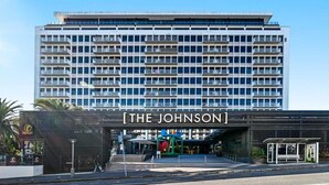 Een modern hotel met een opvallende ingang en een bord waarop 