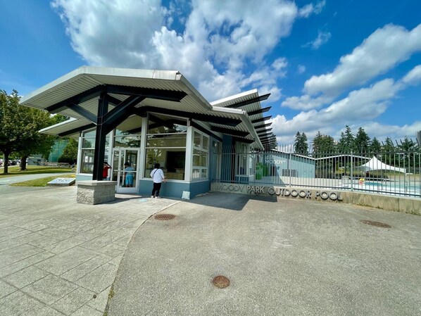 Un espace piscine extérieur moderne, doté d’un coin salon abrité et offrant une vue sur un ciel dégagé.