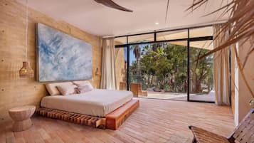 Un dormitorio moderno con una cama grande, vistas al exterior y un cuadro abstracto de gran tamaño en la pared.