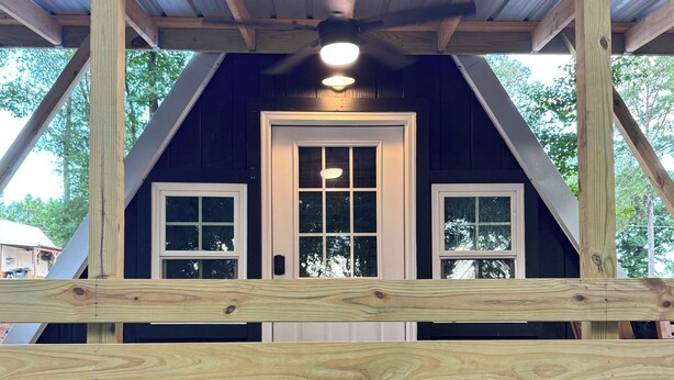A wooden deck with a metal roof structure.