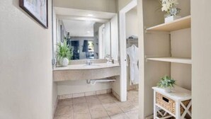 Ein modernes Badezimmer mit großem Spiegel, Waschbecken und Handtuchhalter.